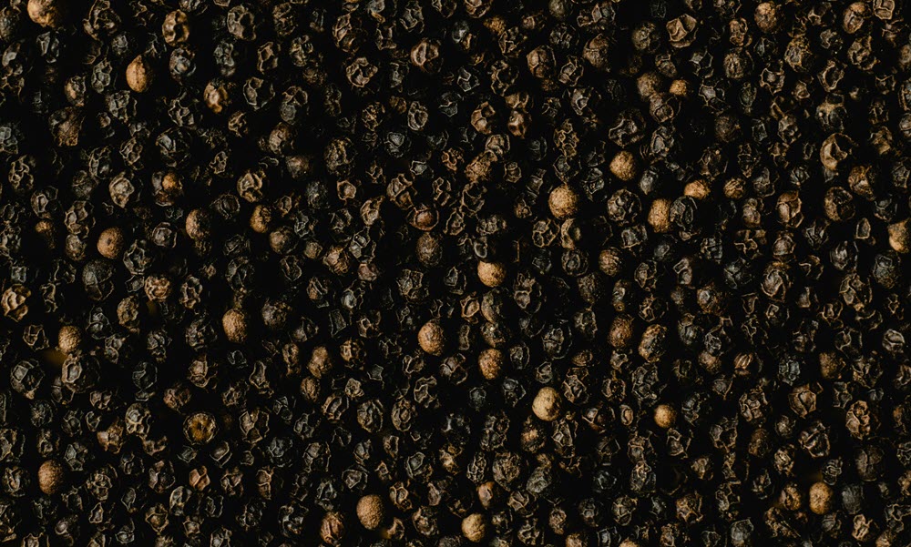 a close up of black peppercorns